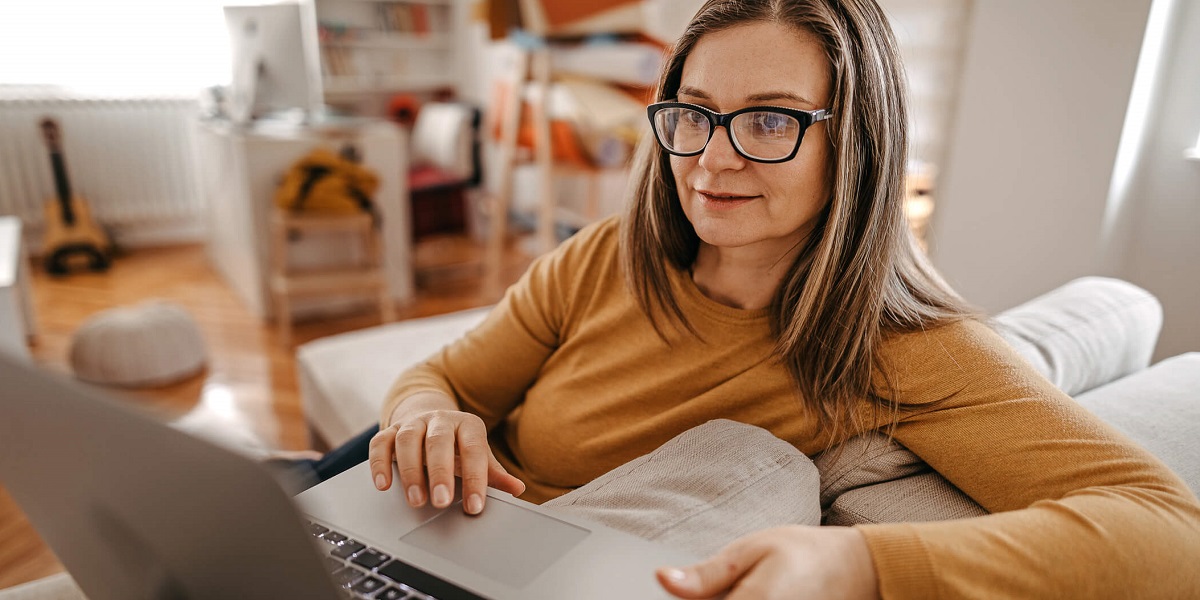 Woman sitting on touch using laptop