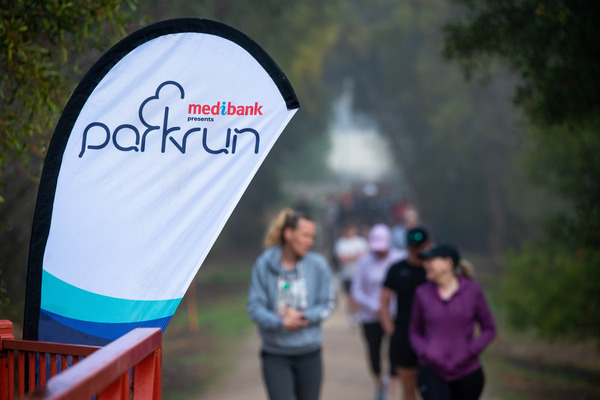 A group of people walking outside participating in parkrun