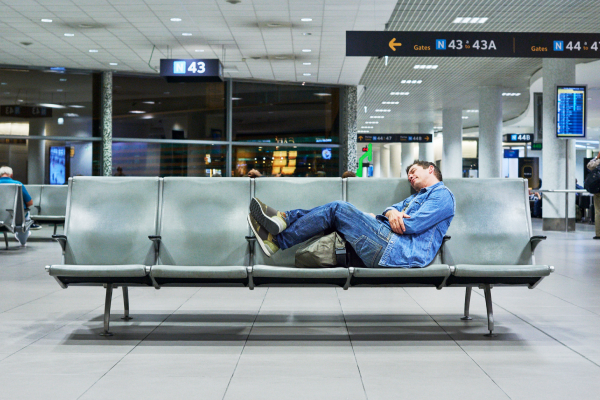 man resting at airport jet lag